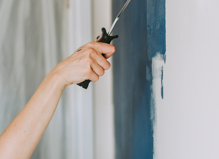 closeup-shot-person-using-paint-rollers-with-color-blue