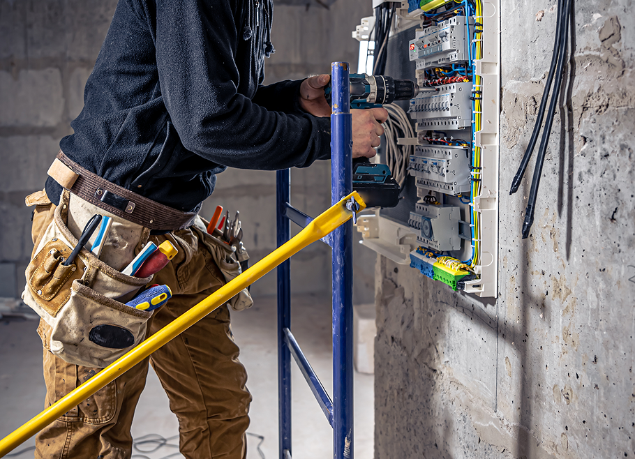 male-electrician-works-switchboard-with-electrical-connecting-cable