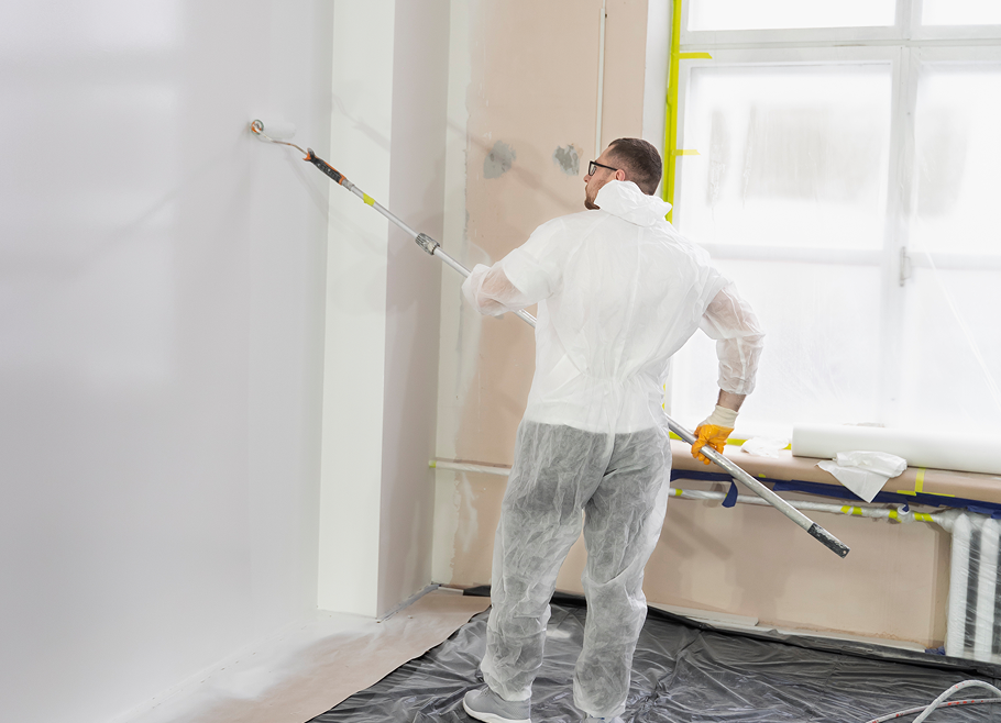 young-worker-painting-wall-full-shot